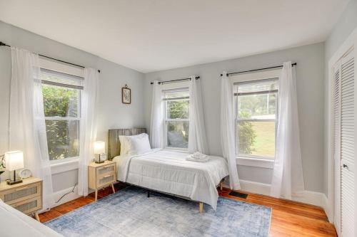 a bedroom with a bed and two windows at Charming Condo near Gillette Stadium in Sharon