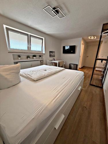 a large white bed in a room with a window at *moderne Wohnung ANTON in VS mit Küche+Bad in Villingen-Schwenningen