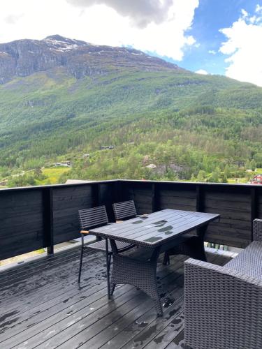 a table and chairs on a deck with a mountain at Tiritoppen Cabin in Loen