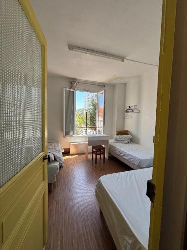 a room with two beds and a window at Soleil in Villejuif