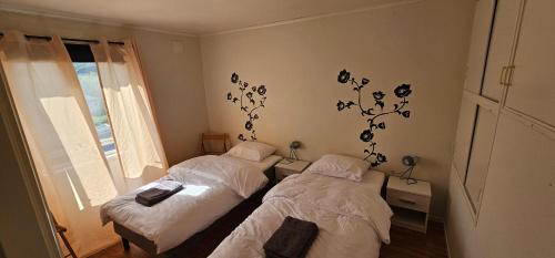 two twin beds in a room with a window at Nord Hus 3 in Loppa