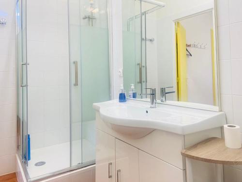 a white bathroom with a sink and a shower at Soleil in Villejuif