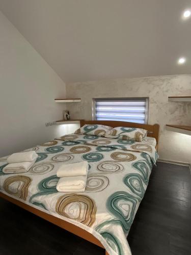 a bedroom with a large bed with towels on it at Apartman Nastić in Lazarevac