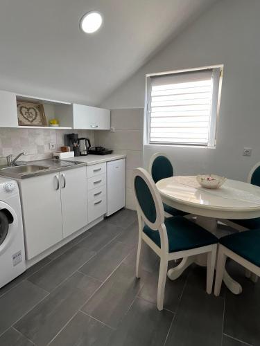 a kitchen with a table and chairs and a sink at Apartman Nastić in Lazarevac