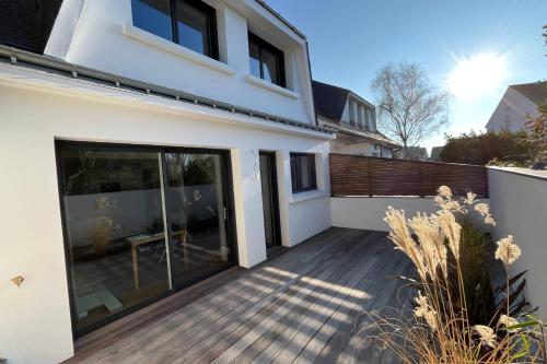 a house with a large glass door on a deck at Maison proche grande plage in Quiberon