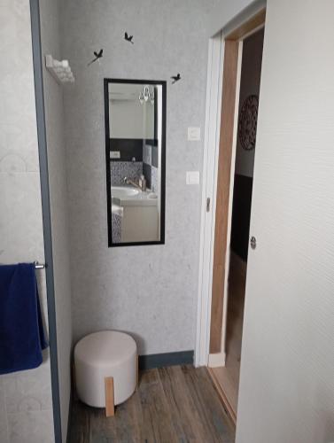 a bathroom with a mirror on the wall and a stool at La Planoise in Autun
