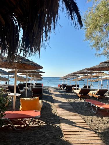 a row of chairs and umbrellas on a beach at Almyra Summer Homes in Ierapetra