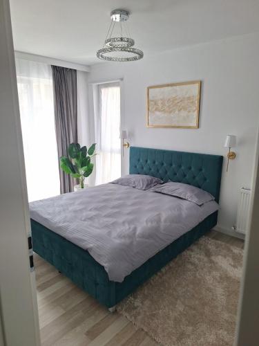 a bed in a bedroom with a blue headboard at Cozy apartment! in Floreşti