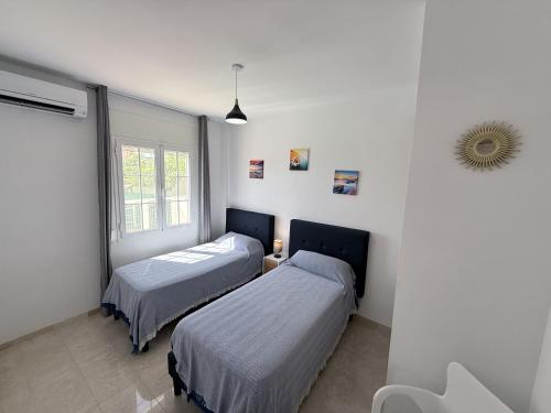 a bedroom with two beds and a window at villa piscina y vistas espectaculares a la montana , gran terraza y aire acondicionado in Cuevas del Almanzora