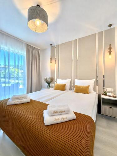 two beds in a hotel room with towels on them at Stella APART Resort & SPA in Władysławowo