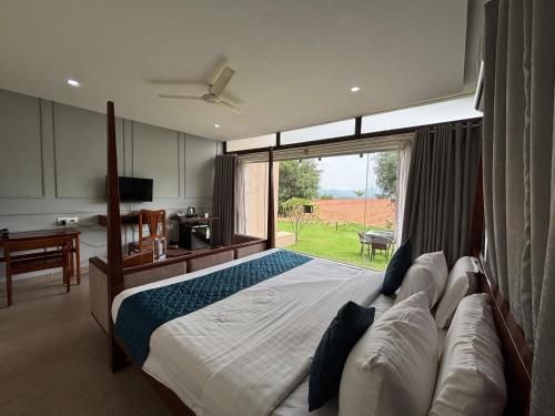 a bedroom with a large bed and a large window at Ravishing Retreat Resort in Rāmanagaram
