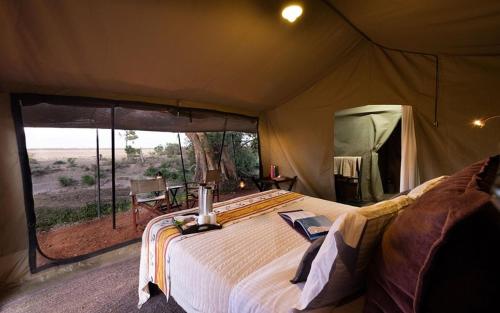 a bedroom with a large bed in a tent at Posho Sunset Mara in Sekenani