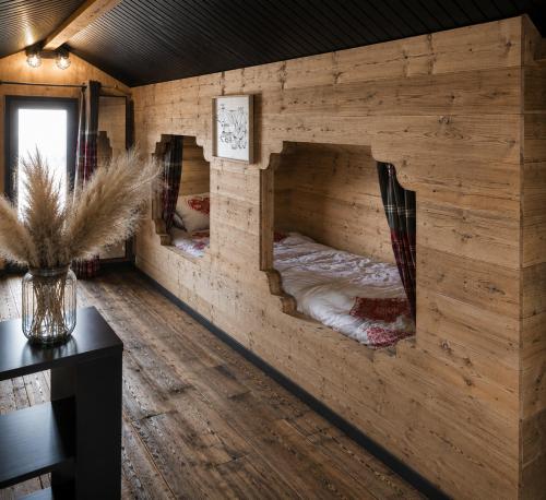 a room with two bunk beds in a log cabin at CHALET COSY A LA MONTAGNE AVEC SAUNA TONNEAU situé à St Laurent en Grandvaux - Proche lacs cascades et pistes de ski in Saint-Laurent-en-Grandvaux