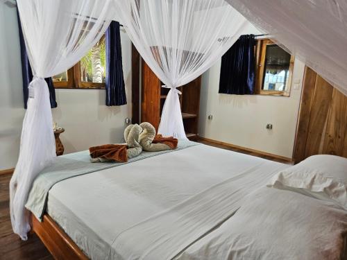 a bed with two teddy bears sitting on top of it at Belar Reef Bungalows in Nembrala