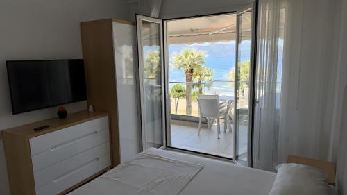 a bedroom with a bed and a view of the ocean at Jimi Apartments in Vlorë