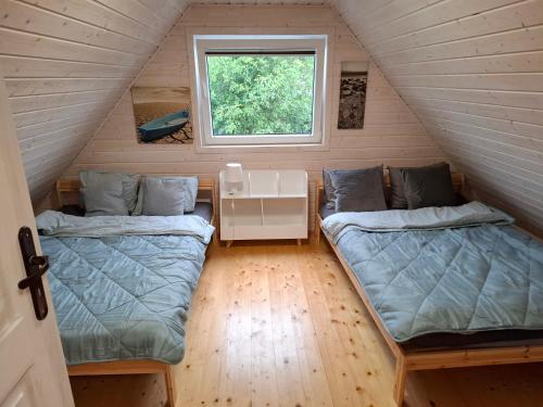 a room with two beds in a tiny house at Domek nad morzem Jerzyk 506-385-791 in Stegna