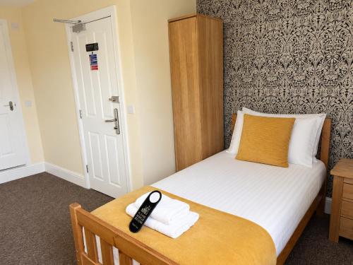 a bedroom with a bed with a remote control on it at The Cornerhouse in Frome