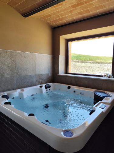 a jacuzzi tub in a room with a window at Agriturismo Marinello in Pienza