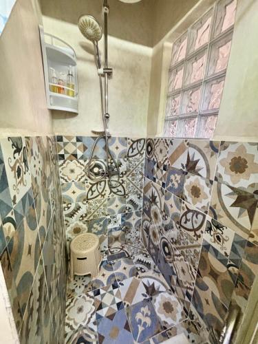a bathroom with a shower and a tiled floor at LOUIZA HOUSE, vue imprenable entre lac et désert in Lalla Takerkoust