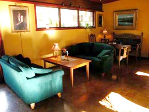 a living room with two couches and a table at Midtnes Hotel in Balestrand