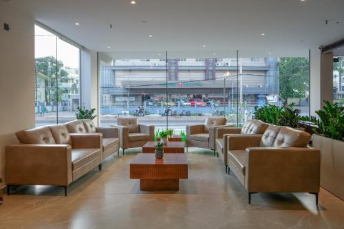 a lobby with couches and a table in a building at Alora Grand Hotel Calicut in Kozhikode