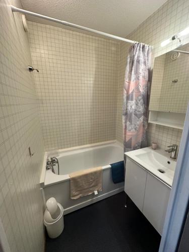 a bathroom with a tub and a sink at Beau studio Pra loup 1500 in Pra-Loup