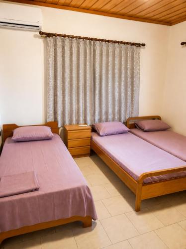 two beds in a room with a window at Villa Sofia in Mesimvría
