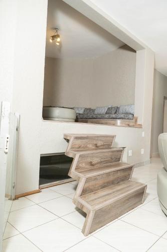 a staircase in a living room with wooden steps at 157 on North-Sandton in Johannesburg