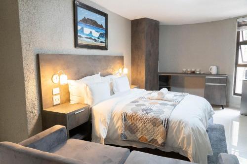 a bedroom with a large bed and a chair at 157 on North-Sandton in Johannesburg