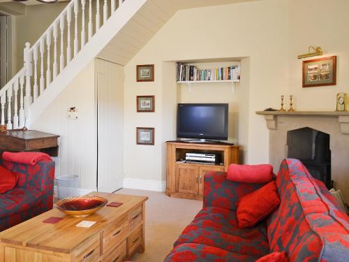a living room with two couches and a tv at The Old School House in Tideswell