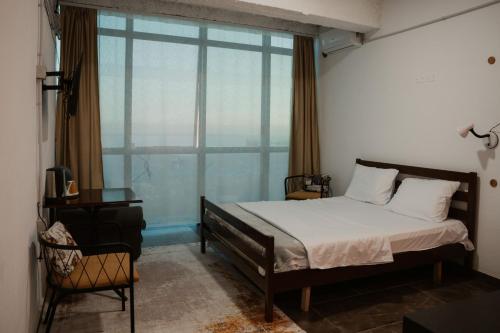 a bedroom with a bed and a large window at Backpacker Hostel Kruje in Krujë