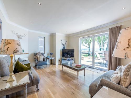 a living room with a couch and a table at Duck Bay Cottage 2 - Uk43935 in Balloch