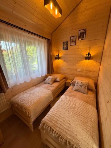 a bedroom with two beds in a log cabin at Las Się Żyje in Lutowiska