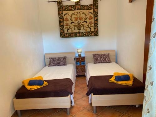 two beds in a room with a picture on the wall at Casa dos Avós in São Brás de Alportel