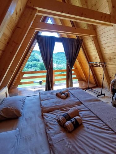 ein großes Bett in einem Zimmer mit einem großen Fenster in der Unterkunft Villa Viktor Šipovo in Šipovo