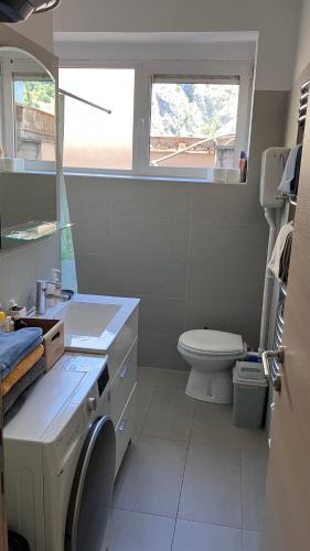 a bathroom with a sink and a toilet and a window at Downtown Apartment in Kotor