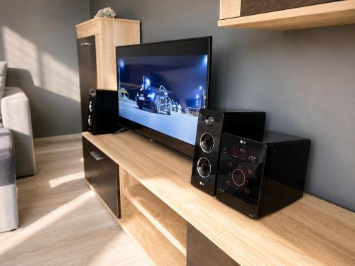 a flat screen tv sitting on top of a entertainment center at BAIO Apart Sapphire in Libiąż