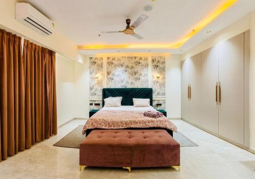 a bedroom with a large bed and a ceiling fan at Galaxy Luxury Stay in Ghaziabad