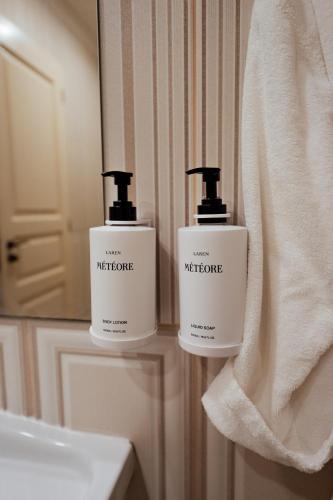 a bathroom with two bottles of soap and a mirror at Sunny Castle Hotel - All Inclusive, Beach and Free parking in Kranevo