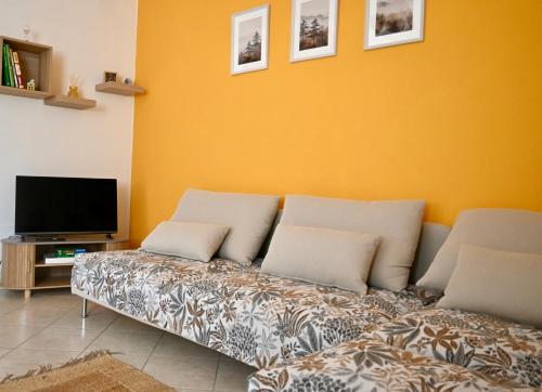a living room with a couch and a tv at Maison Josephine in Chiusa di Pesio