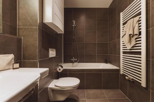 a bathroom with a toilet and a bath tub at Apartments Obernosterer in Kaprun