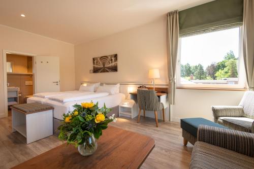 a hotel room with a bed and a living room at Bundt's Hotel & Gartenrestaurant in Hamburg