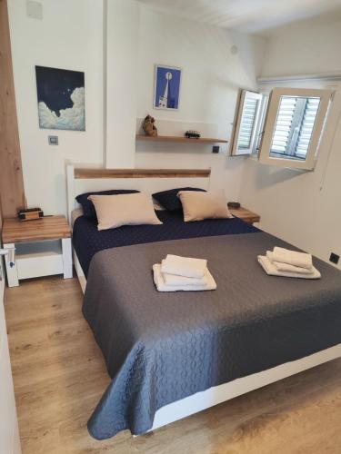 a bedroom with a large bed with two towels on it at Apartman Fjaka in Petrcane
