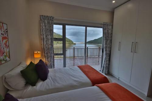 a bedroom with a bed with a view of a balcony at Igoda Mouth Resort in Winterstrand