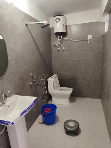 a bathroom with a sink and a toilet and a scale at Vybent hotel kainchi dham in Bhowāli