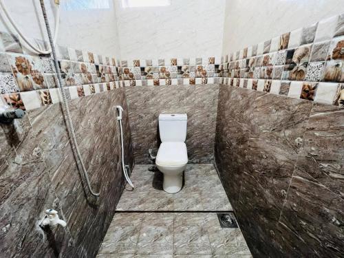 a bathroom with a toilet and a shower at Kamaleswari Villa Trincomalee in Trincomalee