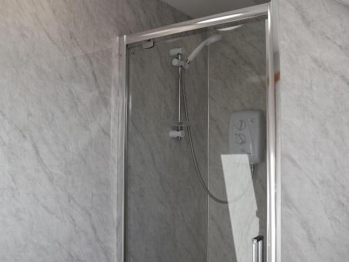 a shower with a glass door in a bathroom at Lochboisdale Cottage in Lochboisdale