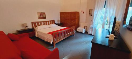 a bedroom with a bed and a red couch at Hotel Pensione Moderna in Bonassola