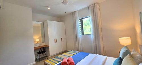 a bedroom with a bed and a desk and a window at Holiday - Comfort - Spacious - Escape in Grand-Baie