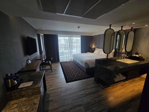 a large hotel room with a bed and a bathroom at Ayathorn Bangkok in Bangkok